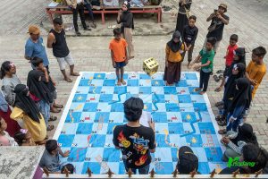 Sejumlah anak mengikuti permainan ular tangga bertema sampah plastik pada program pendidikan konservasi di Huntap Mosinggani Mamboro, Palu, Sulawesi Tengah, Sabtu (1/6/2024). (rindangID/Basri Marzuki)