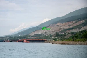 Sebuah tug boat bersiap menarik kapal tongkang bermuatan material galian C untuk pembangunan Ibu Kota Nusantara (IKN) di pesisir Teluk Palu, Sulawesi Tengah, Kamis (12/6/2025). Data dari Minerba One Map Indonesia (MOMI) Kementerian ESDM, sekitar 30 juta ton batu pecah dipasok dari usaha pertambangan di Sulawesi Tengah untuk pembangunan IKN dan hingga akhir 2024 tercatat 69 izin pertambangan galian C aktif di Kota Palu dan Donggala dengan total luas lahan 1.764,41 hektare. (rindang.ID/Basri Marzuki)