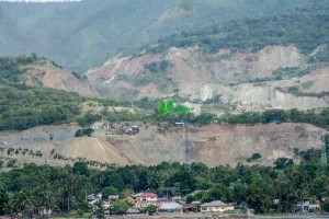 Bentangan perbukitan pesisir yang ditambang untuk material galian C bagi pembangunan Ibu Kota Nusantara (IKN) di pesisir Teluk Palu, Sulawesi Tengah, Kamis (12/6/2025). Data dari Minerba One Map Indonesia (MOMI) Kementerian ESDM, sekitar 30 juta ton batu pecah dipasok dari usaha pertambangan di Sulawesi Tengah untuk pembangunan IKN dan hingga akhir 2024 tercatat 69 izin pertambangan galian C aktif di Kota Palu dan Donggala dengan total luas lahan 1.764,41 hektare. (rindang.ID/Basri Marzuki)