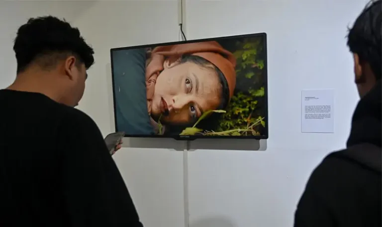 Sejumlah pengunjung memperhatikan sejumlah video art lintas negara yang dipamerkan di Palu, Sulawesi Tengah, Sabtu (13/9/2025). (©rindang.ID/bmz)