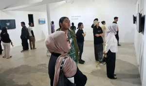 Sejumlah pengunjung memperhatikan sejumlah video art lintas negara yang dipamerkan di Palu, Sulawesi Tengah, Sabtu (13/9/2025). (©rindang.ID/bmz)