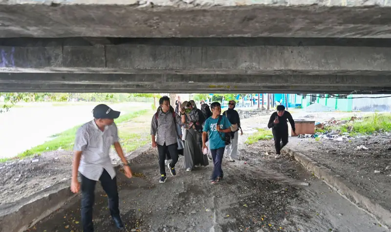 Peserta walking tour melewati kolong Jembatan 1 Palu. (© rindang.ID/bmz)