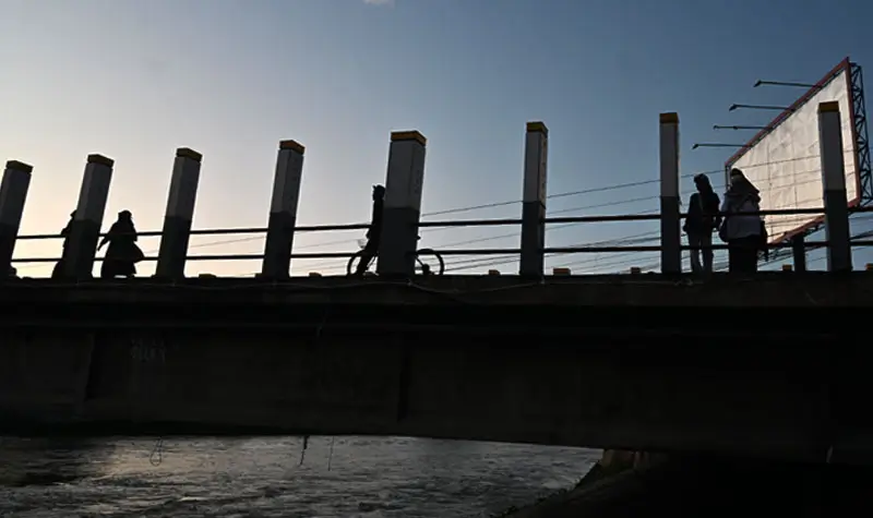 Siluet pesrta walking tour berjalan di atas Jembatan 1 Palu. (© rindang.ID/bmz)