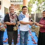 Kepala DLH Kota Palu Mohammad Arif Lamakarate (kedua kanan) bersama Sekretaris DLH Ibnu Mundzir (kedua kiri) dan Kabid Pengelolaan Sampah dan Limbah B3 DLH Hisyam Baba (kiri) menyerahkan daging kurban yang dikemas dengan Kamboti kepada warga di Kantor DLH Kota Palu, Kamis (28/5/2026). (©rindang.id/bmzIMAGES/Basri Marzuki)