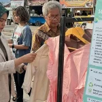 Warga memilih-miliha pakaian untuk ditukarkan dengan baju bekas dalam Swap & Save oleh Bumi Kota Lestari di SFD Palu, Minggu (24/5/2026). (©rindang.ID/AI)